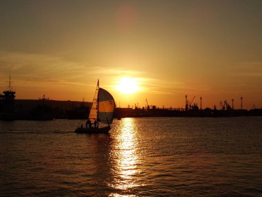 gün batımında denizde küçük tekne