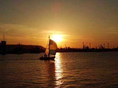 gün batımında denizde küçük tekne