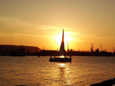 gün batımında denizde küçük tekne