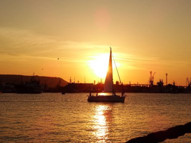 gün batımında denizde küçük tekne