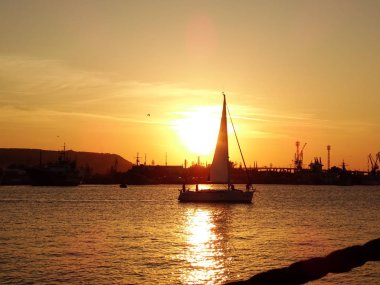 gün batımında denizde küçük tekne