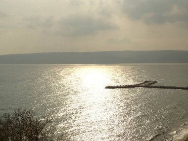 Güneş ışınları düşen ve Deniz Suyu ve İskele yansıyan