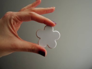 Beyaz çiçek şekli tutan el