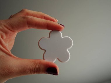 Beyaz çiçek şekli tutan el