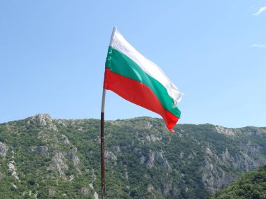 Bir dağın arka planına karşı Bulgar Ulusal bayrağı