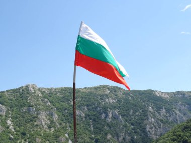 Bir dağın arka planına karşı Bulgar Ulusal bayrağı