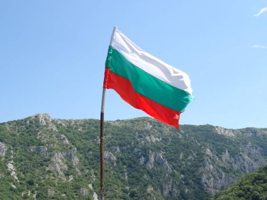 Bir dağın arka planına karşı Bulgar Ulusal bayrağı