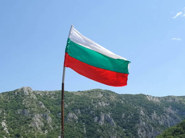 Bir dağın arka planına karşı Bulgar Ulusal bayrağı