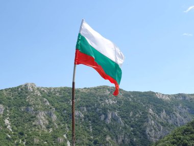 Bir dağın arka planına karşı Bulgar Ulusal bayrağı