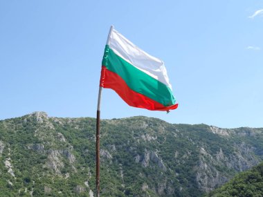 Bir dağın arka planına karşı Bulgar Ulusal bayrağı