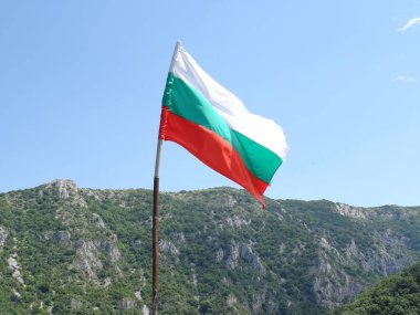 Bir dağın arka planına karşı Bulgar Ulusal bayrağı