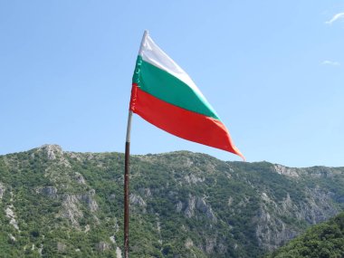 Bir dağın arka planına karşı Bulgar Ulusal bayrağı