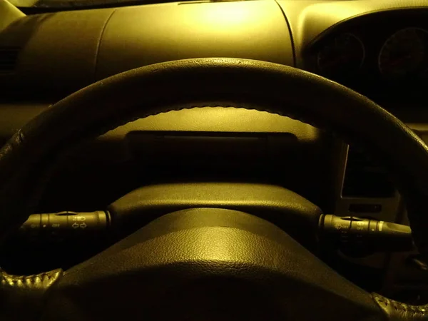 노란색 빛 아래 검은 가죽 자동차 스티어링 휠 — 스톡 사진