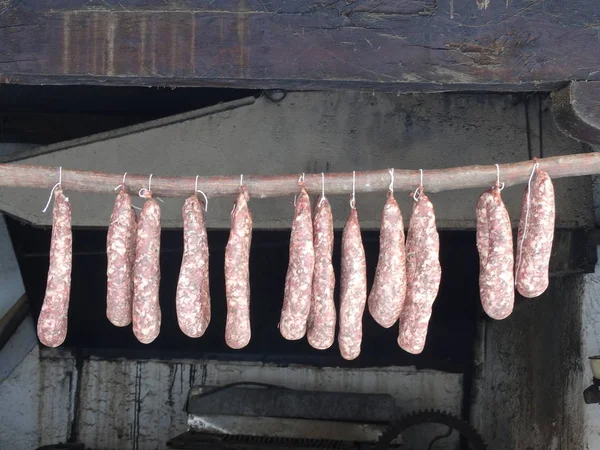 Saucisses séchantes suspendues à un bâton de bois — Photo