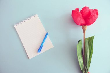 Boş Defter, Mavi Kalem ve Kırmızı Kağıt Çiçek bir Li izole