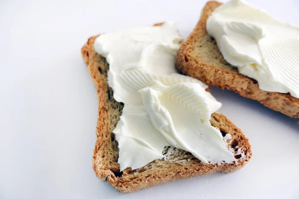 Dos tostadas de pan con queso crema aislado sobre un fondo blanco — Foto de Stock