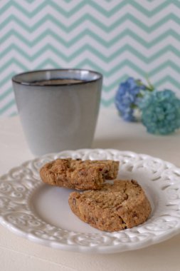 Beyaz ve Yeşil Zikzak Backg Üzerinde Caffee ile Tabakta Kurabiyeler