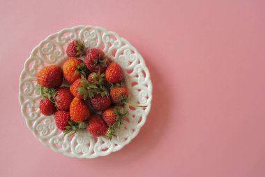 Açık Pembe Arka Plan üzerinde izole vintage beyaz plaka çilek