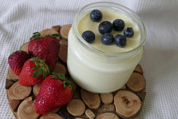 Yogur casero en un tarro con fresas frescas y arándanos — Foto de Stock