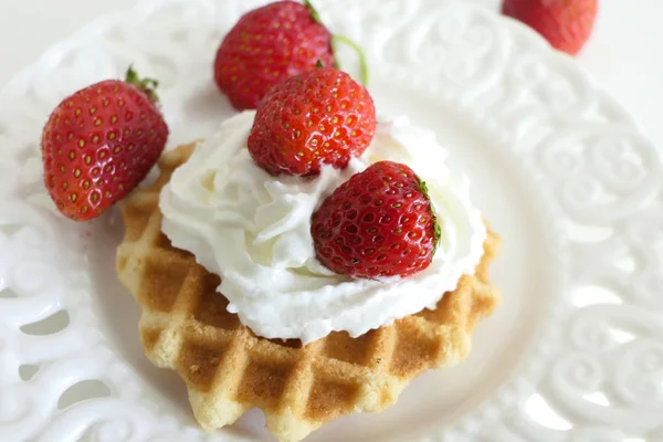 Waffle com creme e morangos em uma placa branca isolada em — Fotografia de Stock