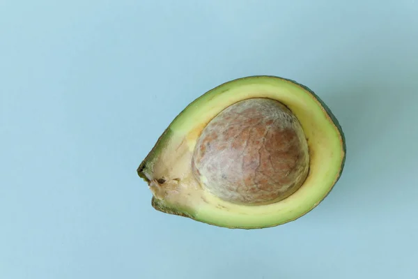 Avocado halb isoliert auf blauem Hintergrund — Stockfoto