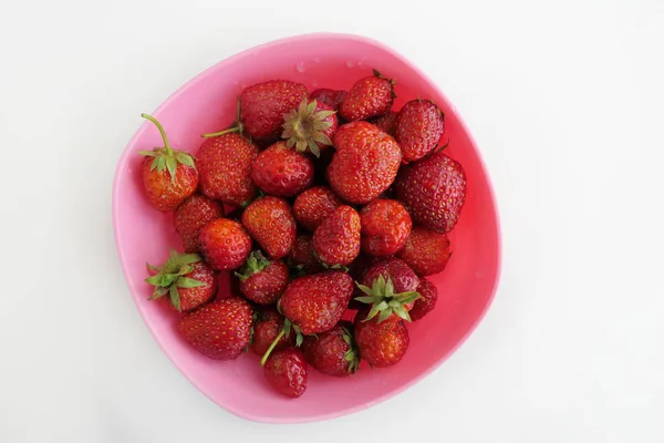 Frische Erdbeeren in einer rosa Schüssel isoliert auf weißem Hintergrund — Stockfoto