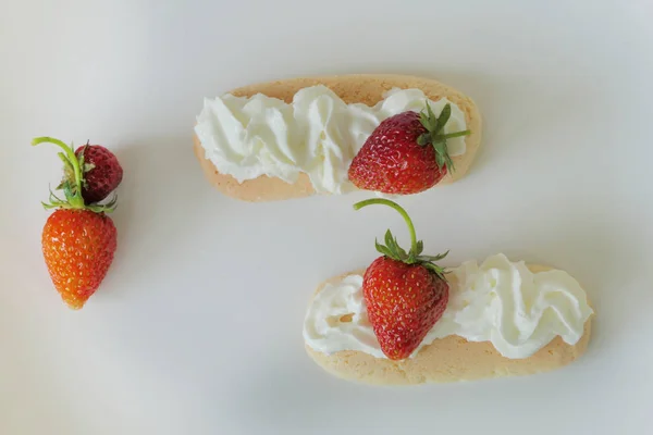 Kekse mit Sahne und Erdbeeren isoliert auf weißem Backblech — Stockfoto
