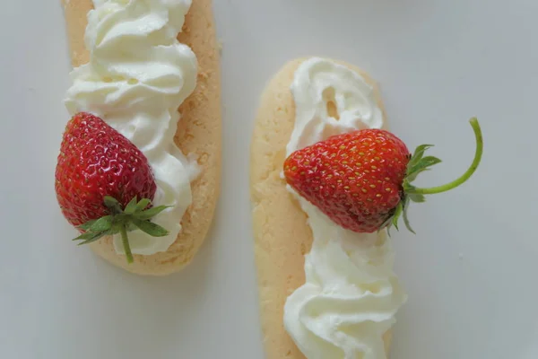 Kekse mit Sahne und Erdbeeren isoliert auf weißem Backblech — Stockfoto