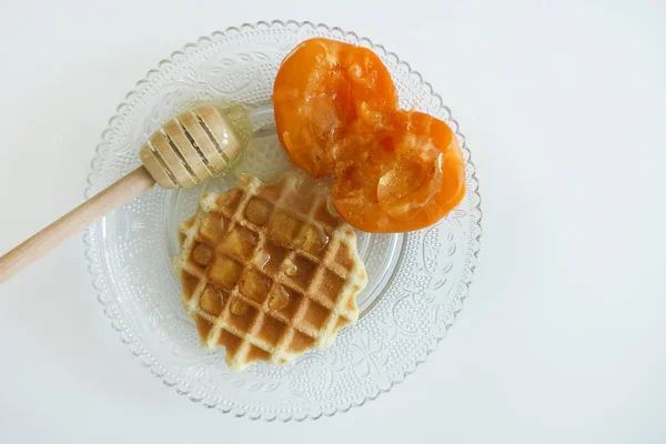 Waffle com mel e damascos isolados em um fundo branco — Fotografia de Stock