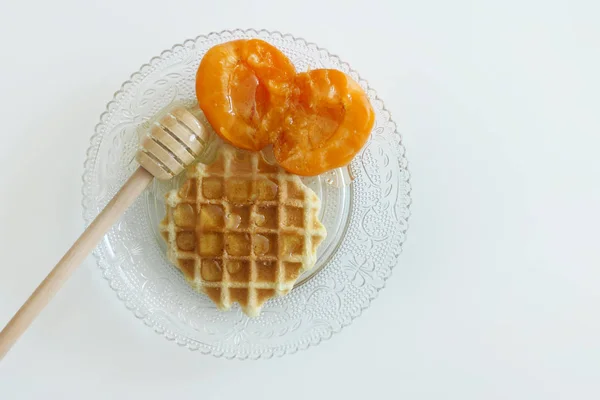 Waffle com mel e damascos isolados em um fundo branco — Fotografia de Stock