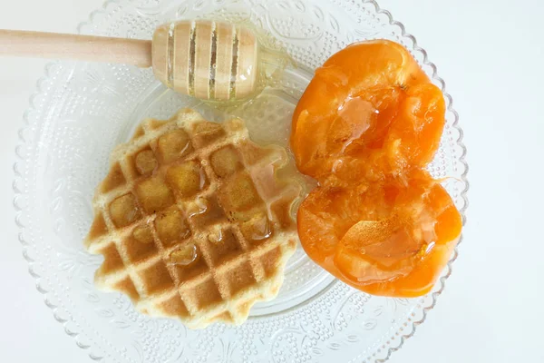 Waffle com mel e damascos isolados em um fundo branco — Fotografia de Stock