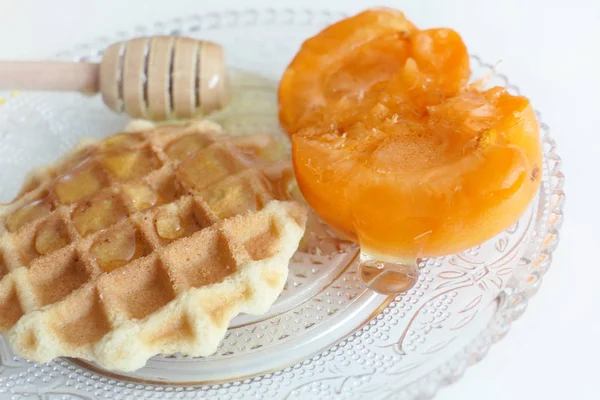 Waffle com mel e damascos isolados em um fundo branco — Fotografia de Stock