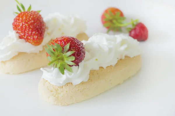 Kekse mit Sahne und Erdbeeren isoliert auf weißem Backblech — Stockfoto