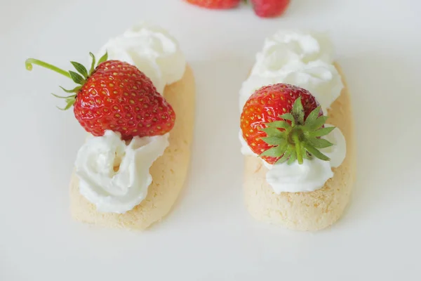 Kekse mit Sahne und Erdbeeren isoliert auf weißem Backblech — Stockfoto