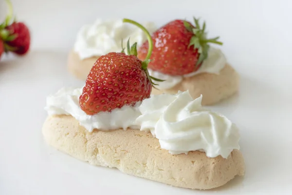 Kekse mit Sahne und Erdbeeren isoliert auf weißem Backblech — Stockfoto