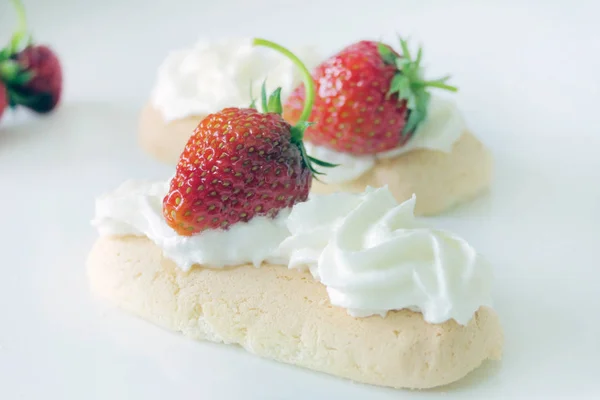 Kekse mit Sahne und Erdbeeren isoliert auf weißem Backblech — Stockfoto