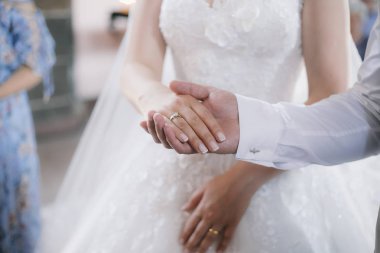 Gelin ve damat el ele tutuşuyorlar.