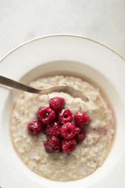 Ev yapımı rustik sağlıklı kahvaltı kavramı - yulaf ezmesi ahududu ve tatlım, zarif görsel tarz