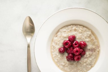 Ev yapımı rustik sağlıklı kahvaltı kavramı - yulaf ezmesi ahududu ve tatlım, zarif görsel tarz