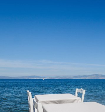 Beyaz Restoran tablolar sahilde yaz - seyahat, tatil ve yaz konsepti. Deniz manzaralı mükemmel bir öğle yemeği