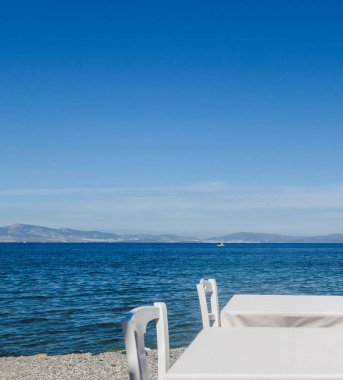 Beyaz Restoran tablolar sahilde yaz - seyahat, tatil ve yaz konsepti. Deniz manzaralı mükemmel bir öğle yemeği