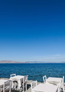 Beyaz Restoran tablolar sahilde yaz - seyahat, tatil ve yaz konsepti. Deniz manzaralı mükemmel bir öğle yemeği