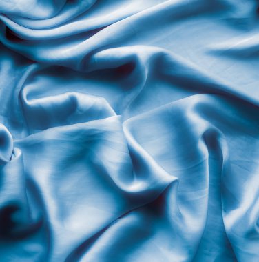 Mavi yumuşak ipek dalgalar, flatlay - şık kumaş dokular, arka ve modern pastel renklerle kavramı. Lüks dokunuş hissediyorum