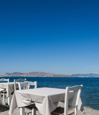 Beyaz Restoran tablolar sahilde yaz - seyahat, tatil ve yaz konsepti. Deniz manzaralı mükemmel bir öğle yemeği