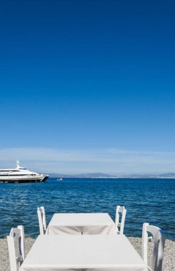 Beyaz Restoran tablolar sahilde yaz - seyahat, tatil ve yaz konsepti. Deniz manzaralı mükemmel bir öğle yemeği