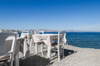 Beyaz Restoran tablolar sahilde yaz - seyahat, tatil ve yaz konsepti. Deniz manzaralı mükemmel bir öğle yemeği