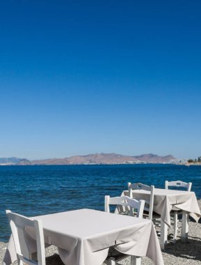 Beyaz Restoran tablolar sahilde yaz - seyahat, tatil ve yaz konsepti. Deniz manzaralı mükemmel bir öğle yemeği