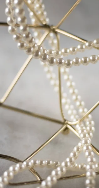 Pearl necklace on golden marble, ethical jewellery - luxury background, jewelry as a gift concept. Pearls are girl's best friends