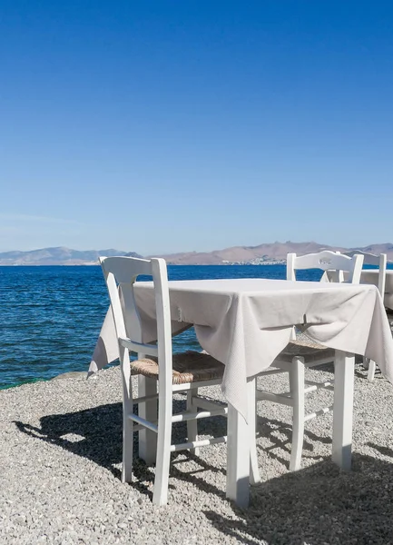 Beyaz Restoran tablolar sahilde yaz - seyahat, tatil ve yaz konsepti. Deniz manzaralı mükemmel bir öğle yemeği