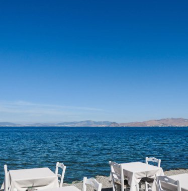 Beyaz Restoran tablolar sahilde yaz - seyahat, tatil ve yaz konsepti. Deniz manzaralı mükemmel bir öğle yemeği